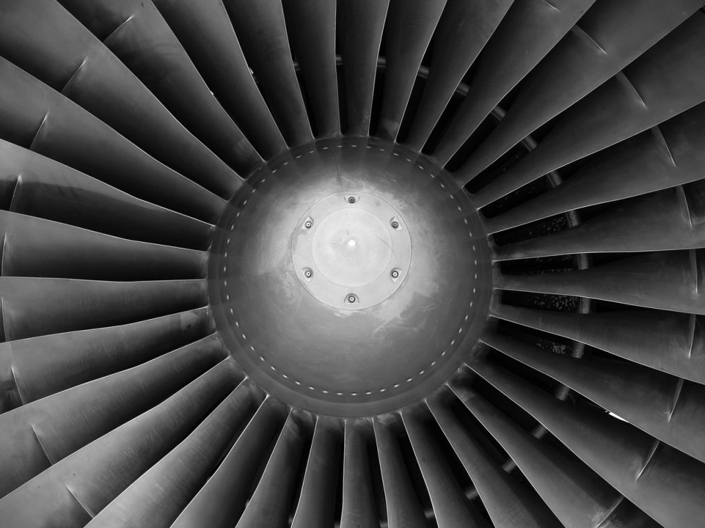 Monochromatic close-up of jet engine turbine blades showcasing intricate engineering design.